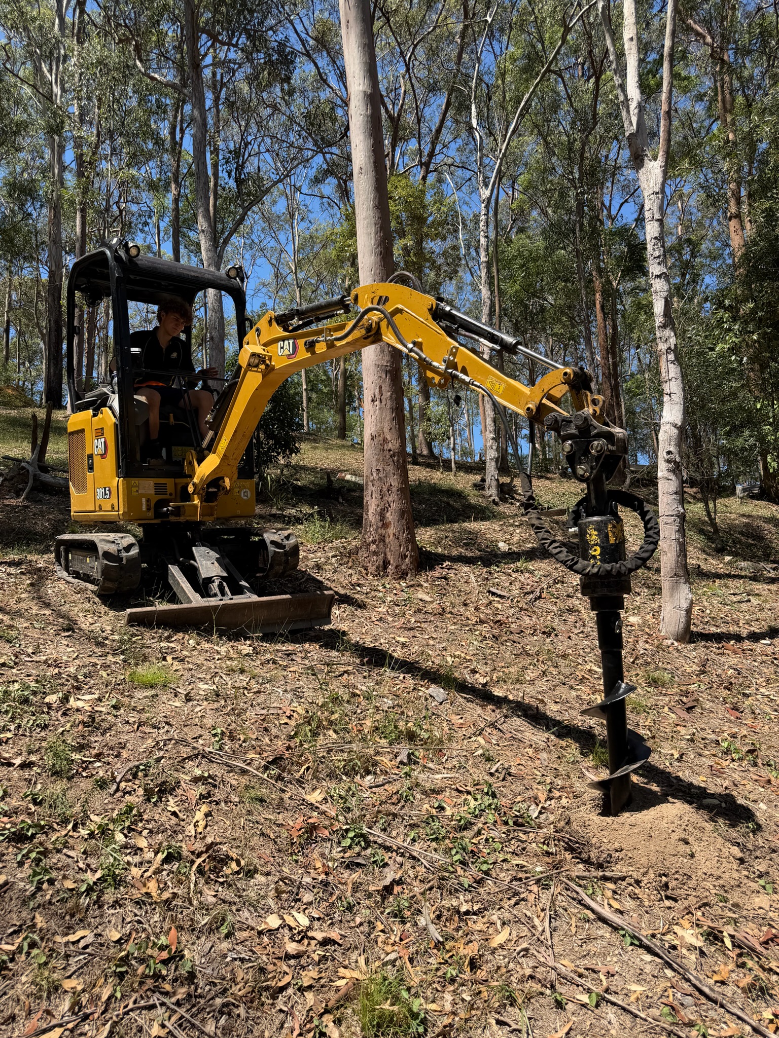 Auger drilling post holes